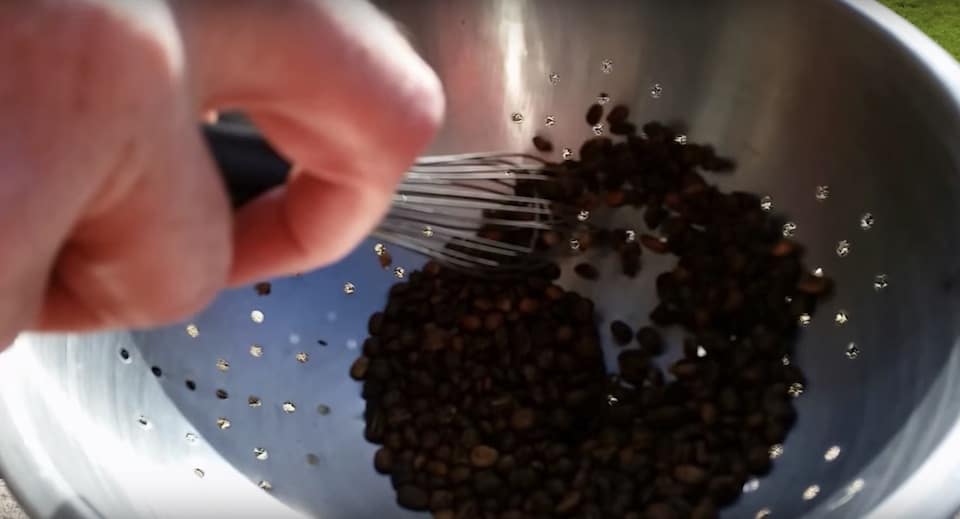 Cooling roasted coffee beans in a metal colander