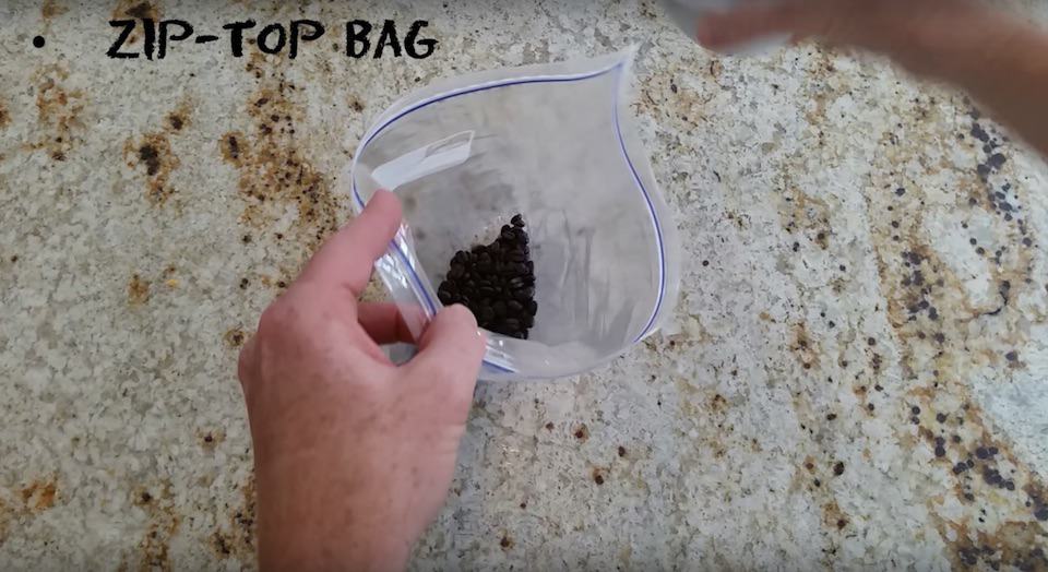 Pouring cooled coffee beans into a ziploc bag