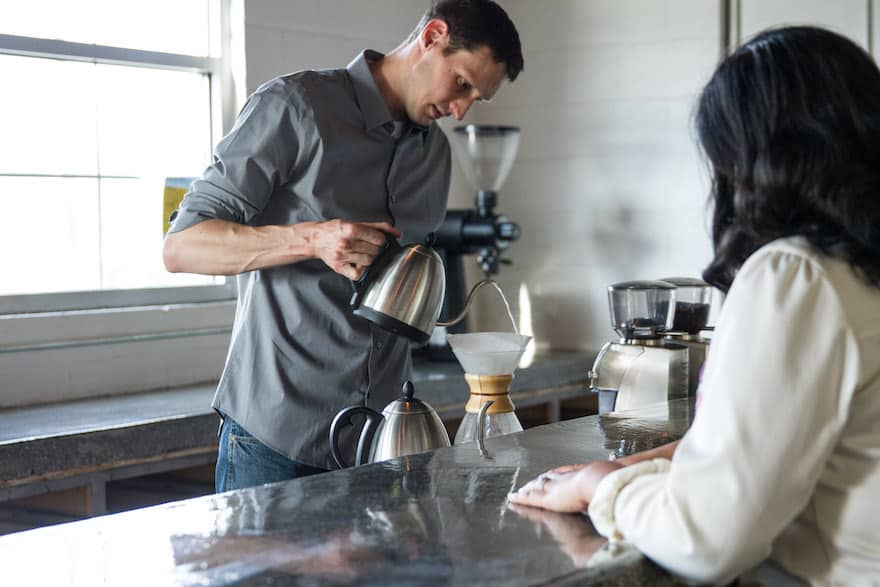 Phil Cook prepares pour-over coffee using a Chemex