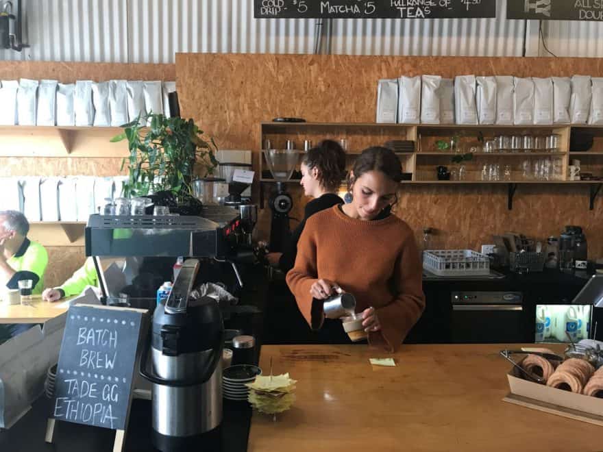 Barista pouring milk at Tell Henry