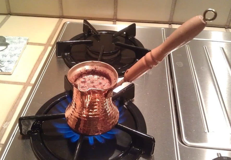 Turkish coffee foaming in a Cezve on the stove