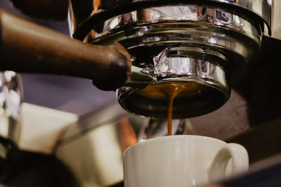 Naked portafilter extracting espresso.