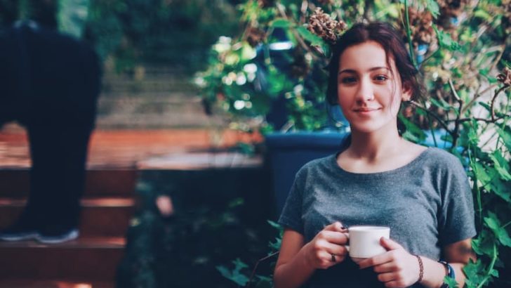 Young woman drinking coffee with a smile on her face