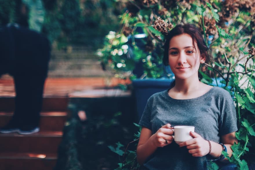 Young woman drinking coffee with a smile on her face