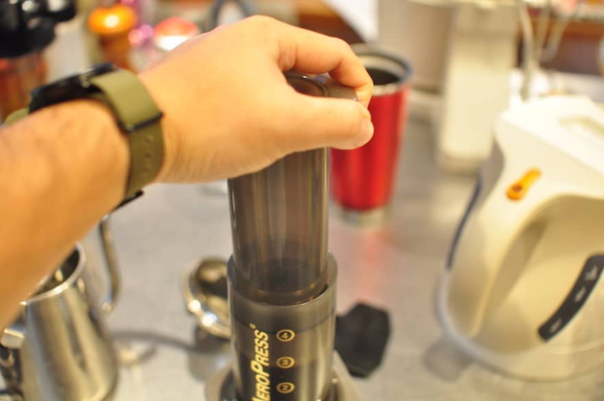 Hand pushing the plunger on an Aeropress