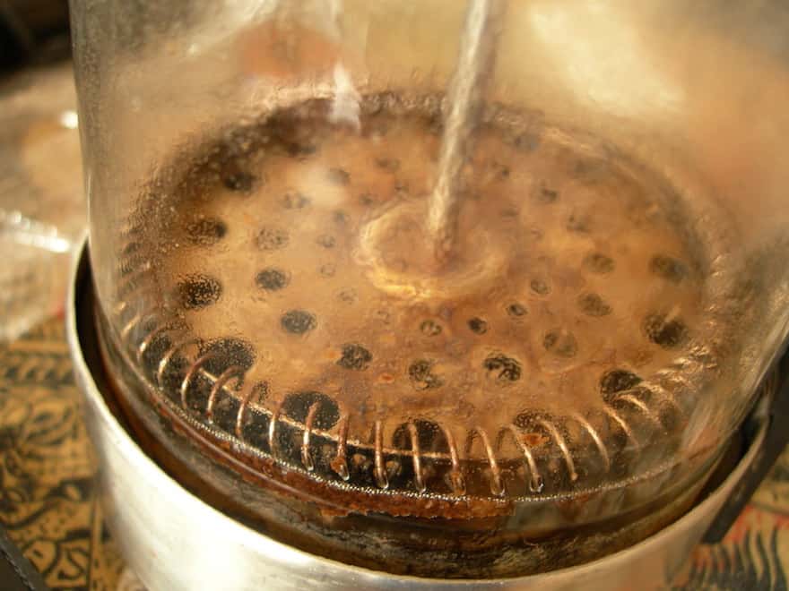 Coffee grounds and sludge at the bottom of a French press after brewing
