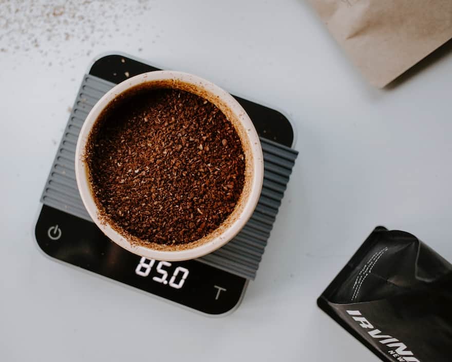 Coarse coffee grounds in a bowl on a kitchen scale