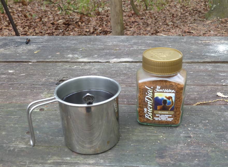 Instant coffee on a picnic table at a campsite
