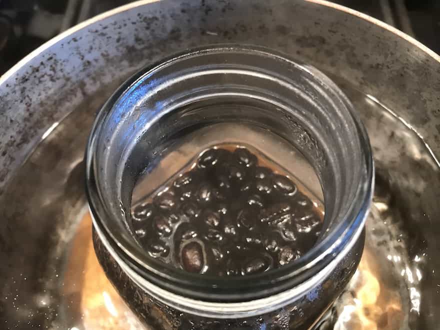 Coffee beans in mason jar after 30 minutes of simmering