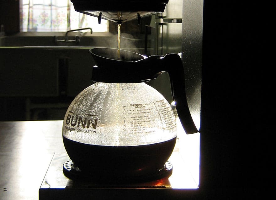 Coffee brewing in a Bunn coffee maker in a sunny kitchen