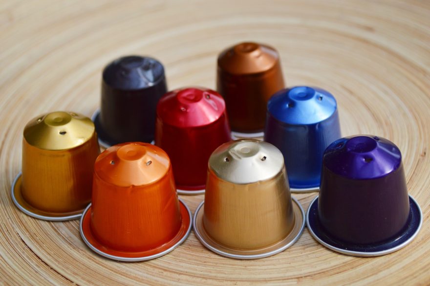 Eight used Nespresso capsules with punctured holes in the end