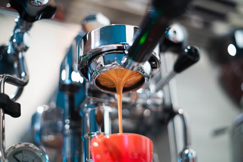 A nice stream of espresso flows from a portafilter into a cup