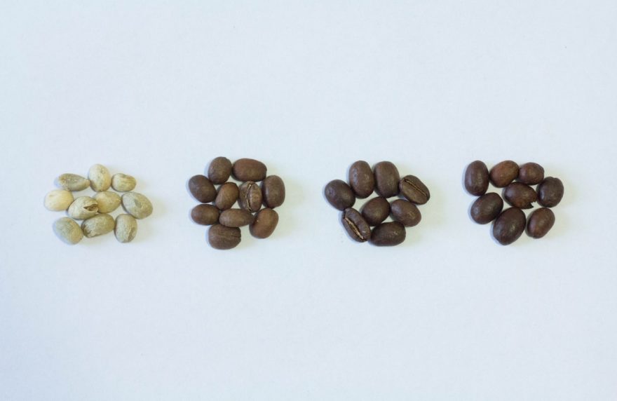 Four small piles of coffee beans, roasted to different degrees
