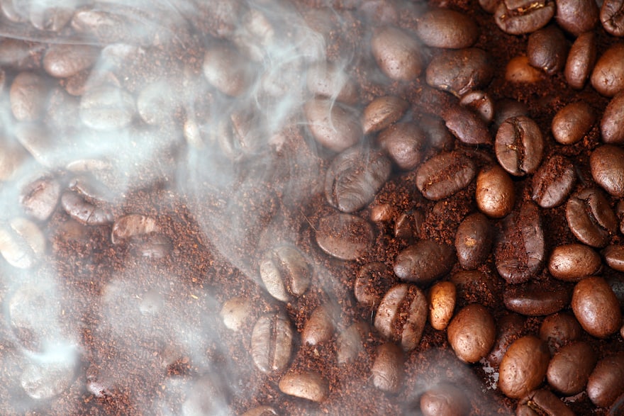 Smoke rises from freshly roasted coffee beans