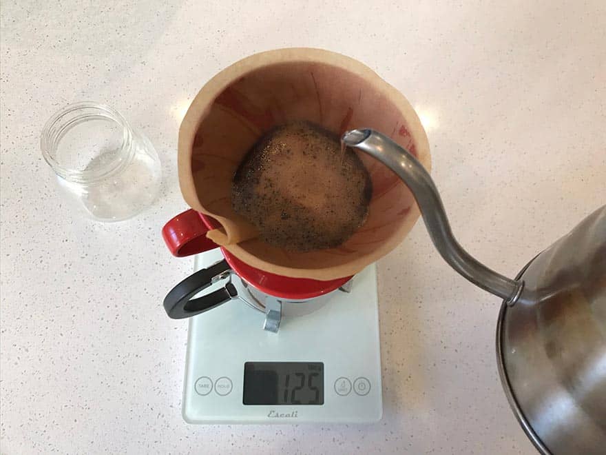 Coffee brewing in a Hario V60 pour-over cone on top of a scale.