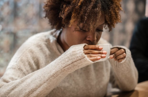 A woman tastes her coffee