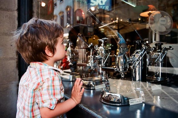 Boy looking at La Pavoni espresso machines in a shop window