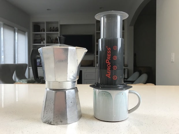 A moka pot and an AeroPress standing side-by-side on a kitchen counter