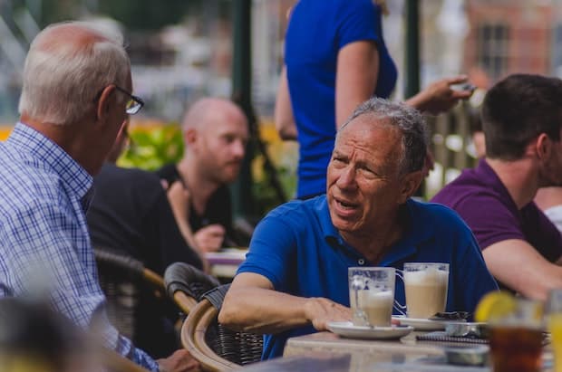 Two gentlemen have an animated discussion over caffe lattes outside an Amsterdam coffee shop