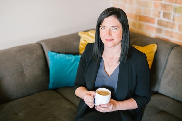 Woman holding a cup of coffee that seems to displease her