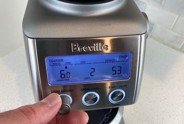 Closeup of the Breville Smart Grinder Pro with a hand on the grind time knob