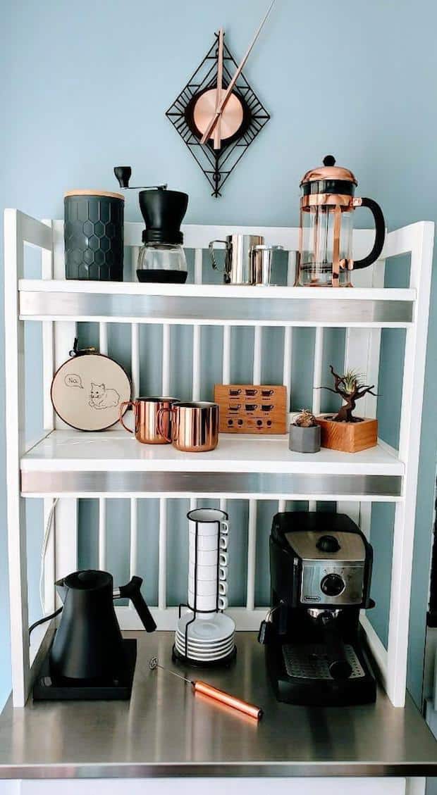 Coffee station with a counter and several shelves stocked with items