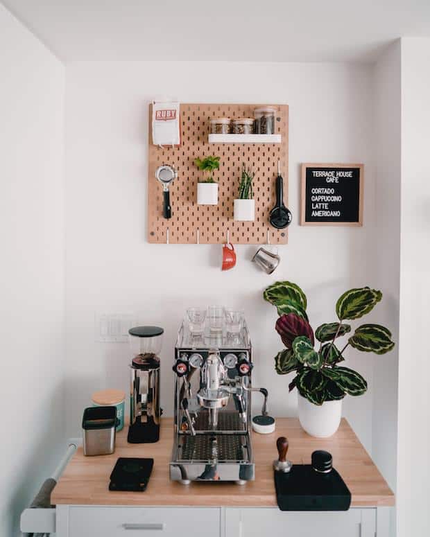 Coffee station with a pegboard on the wall above it