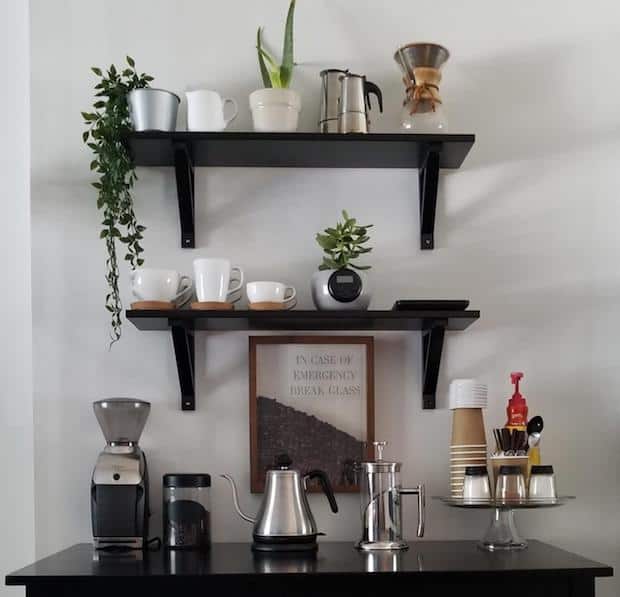 Coffee statin on a dark wood dressers with dark wood shelves on the wall above