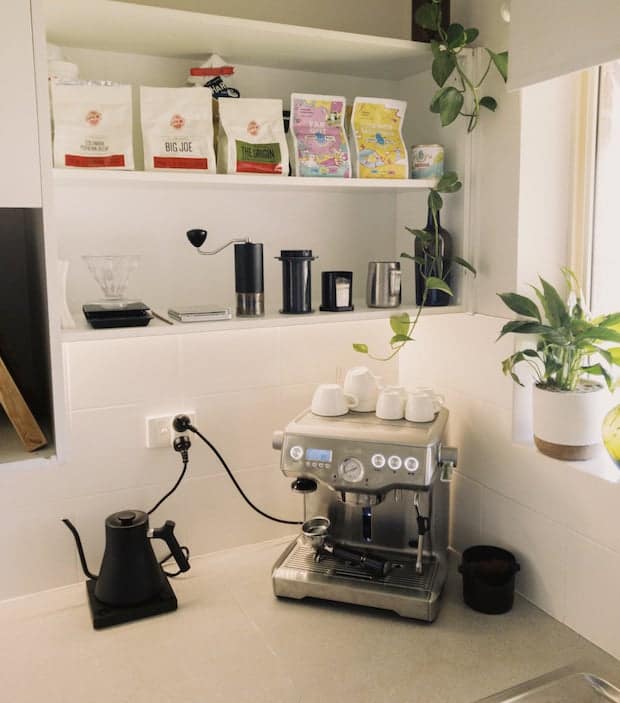 Coffee station on a kitchen counter with shelves above