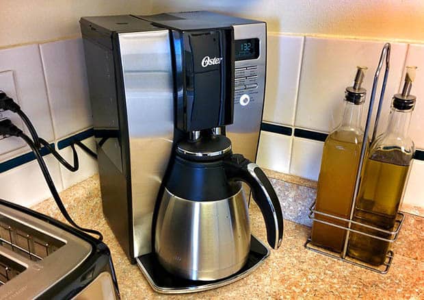 Stainless steel coffee pot on an Oster coffee maker