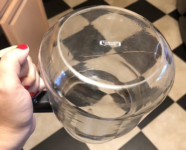 An upside-down Technivorm coffee carafe with a crack in the glass