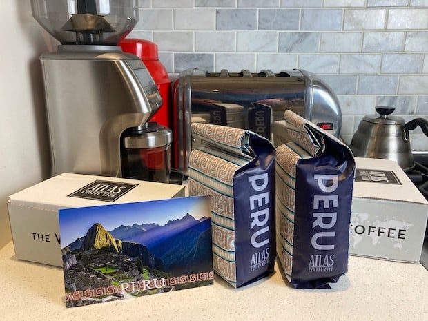 Two bags of coffee from Peru on a kitch counter next to a postcard