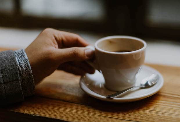 Hand on a cup of artisanal coffee