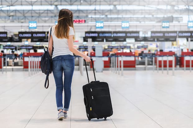 Woman pulling her suitcase along the floor of an airport terminal