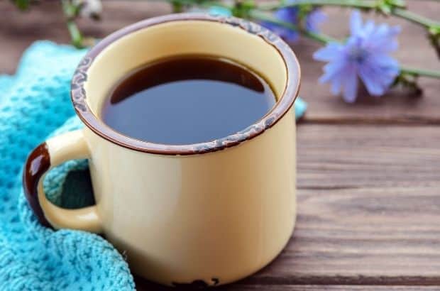 Closeup of a cup of coffee on a picnic table outdoors