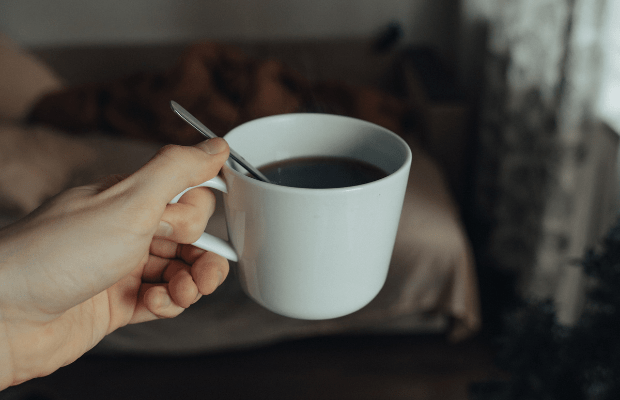 Hand holding out a cup of instant coffee