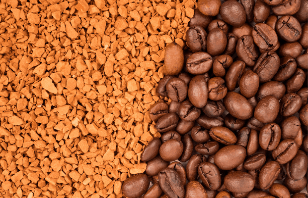 Instant coffee crystals next to roasted coffee beans