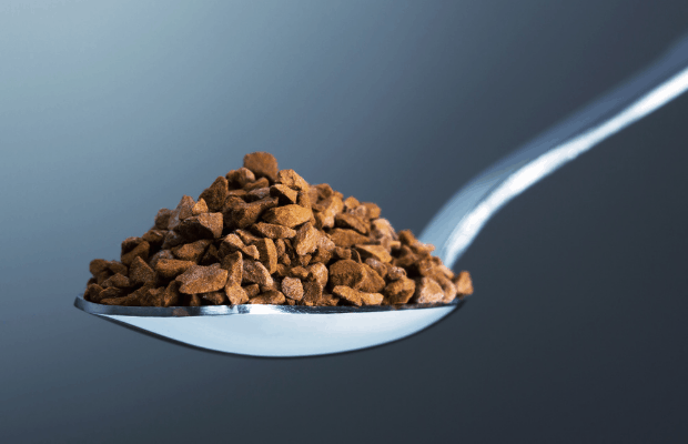 Closeup of a spoon piled high with instant coffee crystals