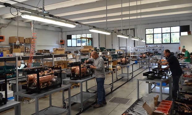 Technicians on a factory floor build espresso machines