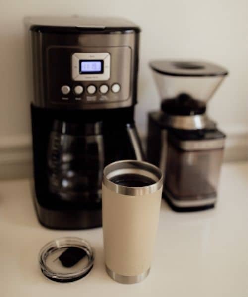 Cuisinart coffee maker on a counter next to a grinder