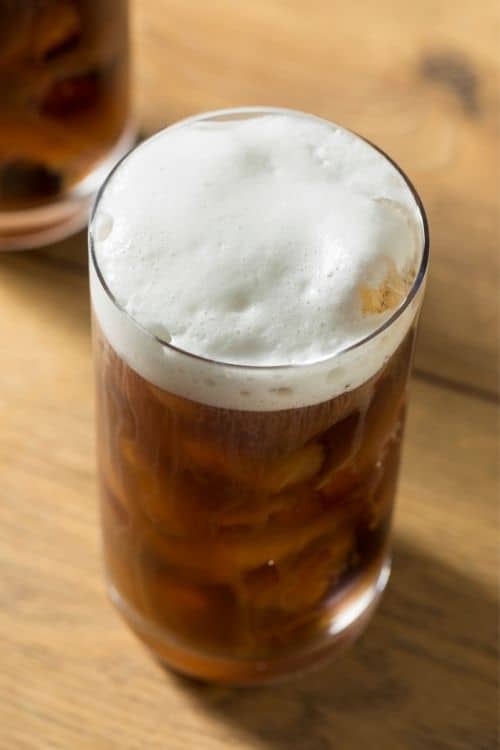 Glass of cold brew coffee topped with a thin layer of cold foam