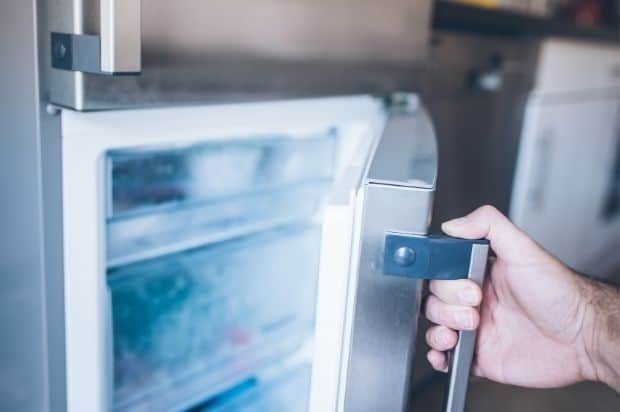 Man's hand opening a freezer door