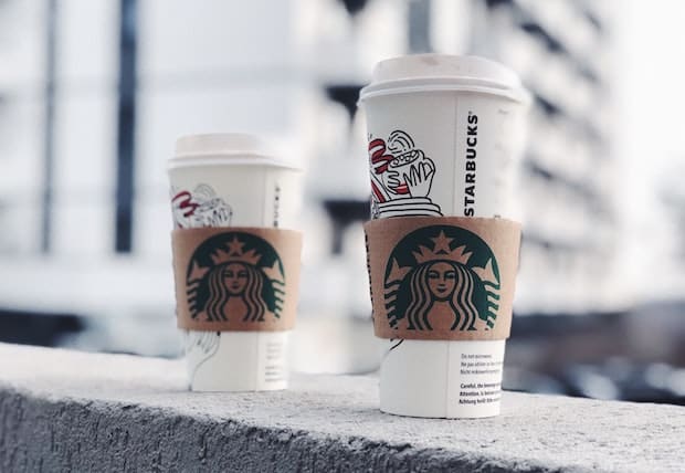 Venti and Grande Starbucks cups perched on a ledge