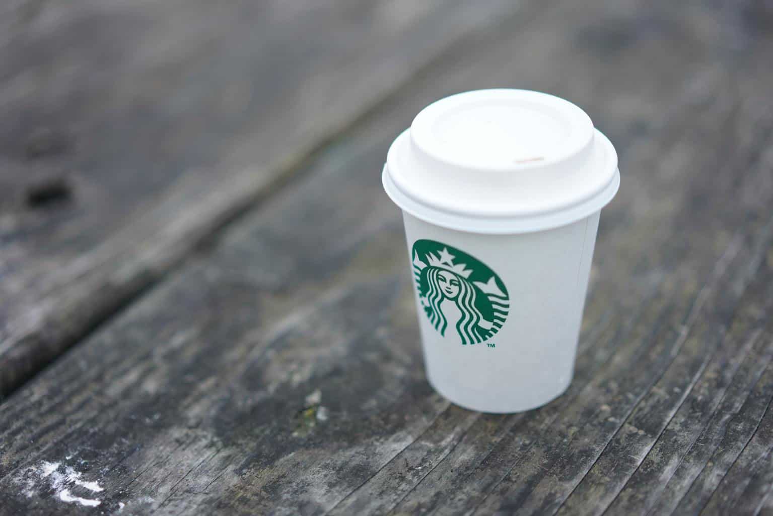 Short Starbucks cup on a wooden plank surface