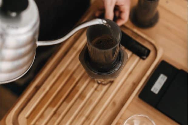 Pouring water from a gooseneck kettle into an AeroPress