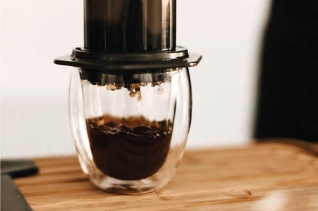 Coffee dripping out of an AeroPress filter into a glass