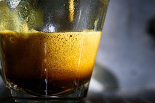 Thick crema on an espresso in a clear glass
