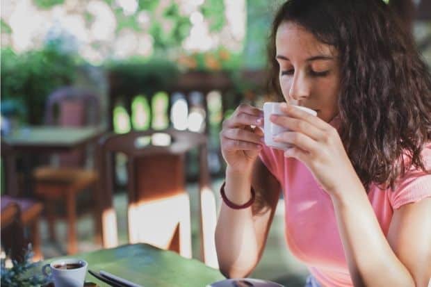 Woman carefully tasting a cup of coffee