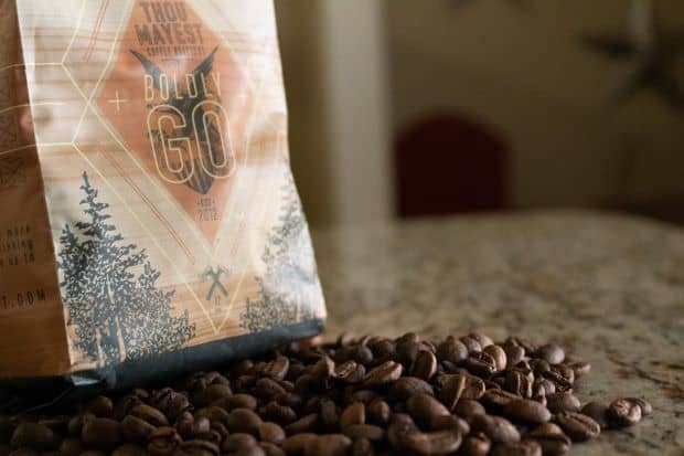 Bag of coffee beans resting on a small pile of coffee beans