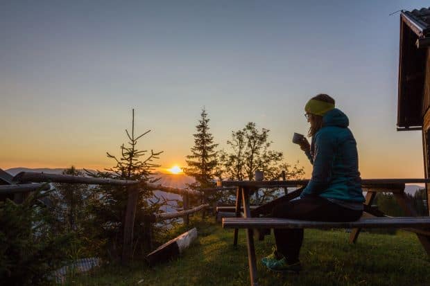 Woman drinking coffee outside near the mountains